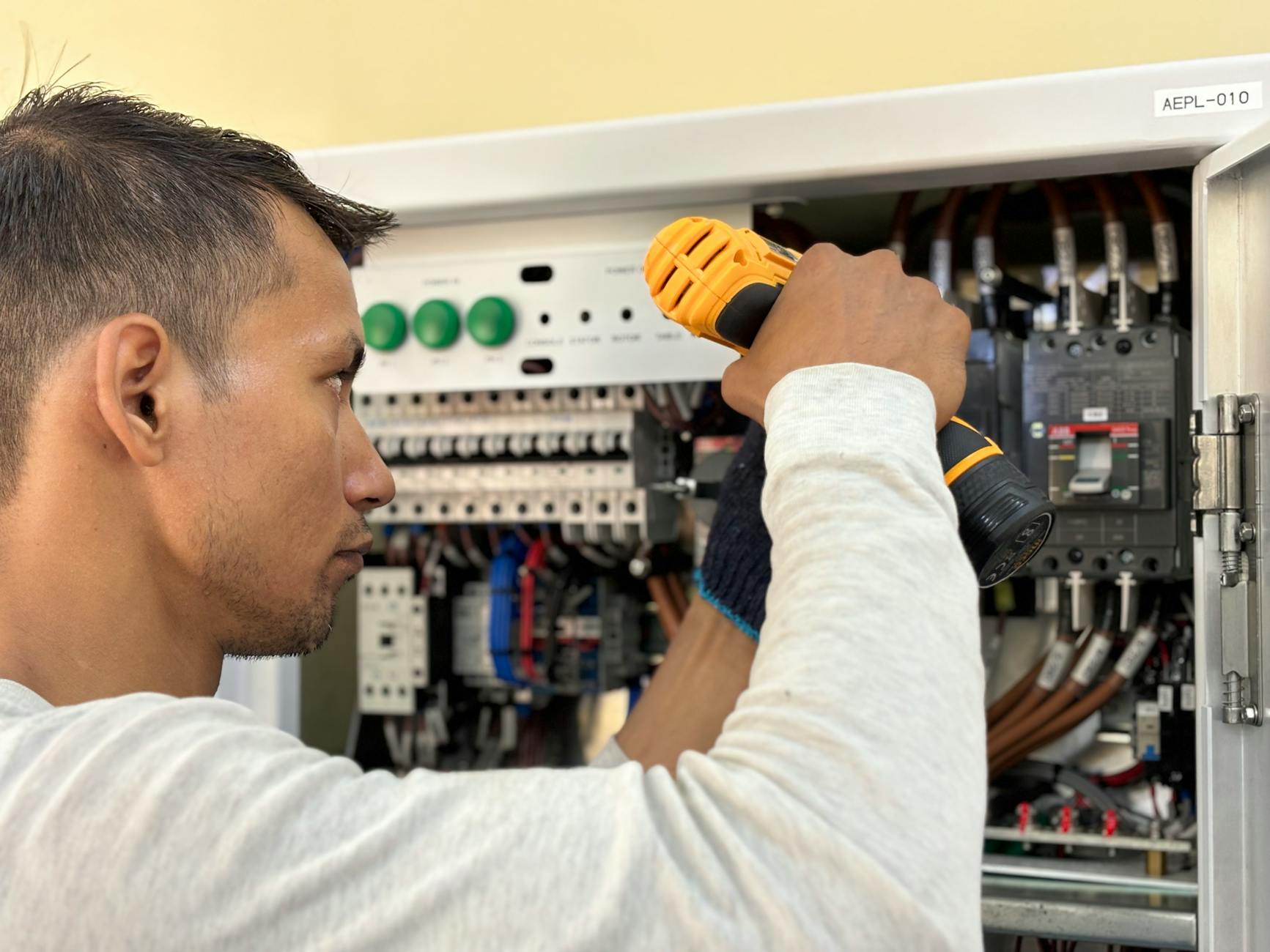 Electrician lucrând la un tablou electric profesional